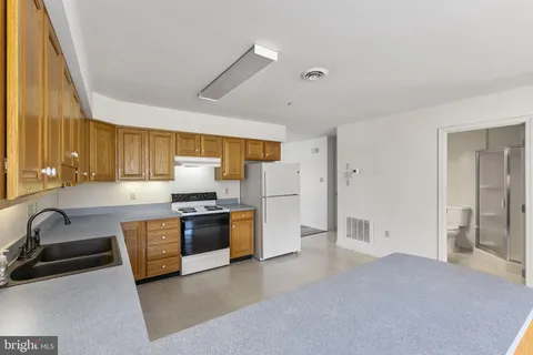 a kitchen with stainless steel appliances granite countertop a sink and a refrigerator