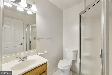 a bathroom with a sink vanity granite and toilet