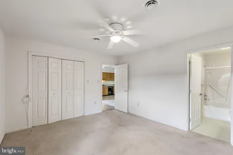 an empty room with closet and a chandelier fan