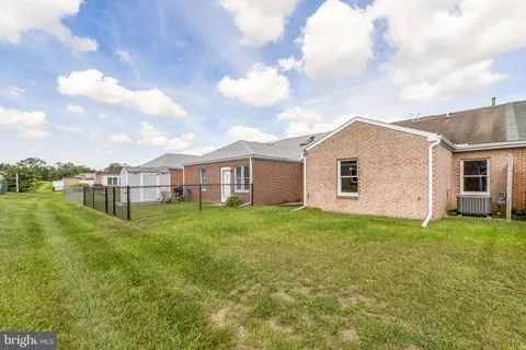 a view of a yard in front of a house with a large tree