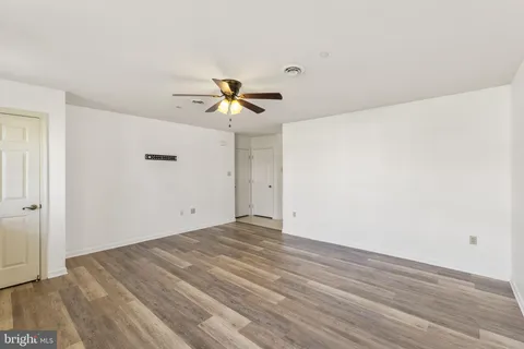 a view of a big room with wooden floor and windows