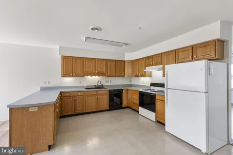 a kitchen with sink a refrigerator and a stove top oven