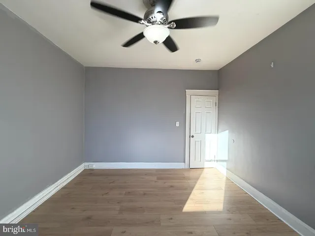an empty room with fan and windows
