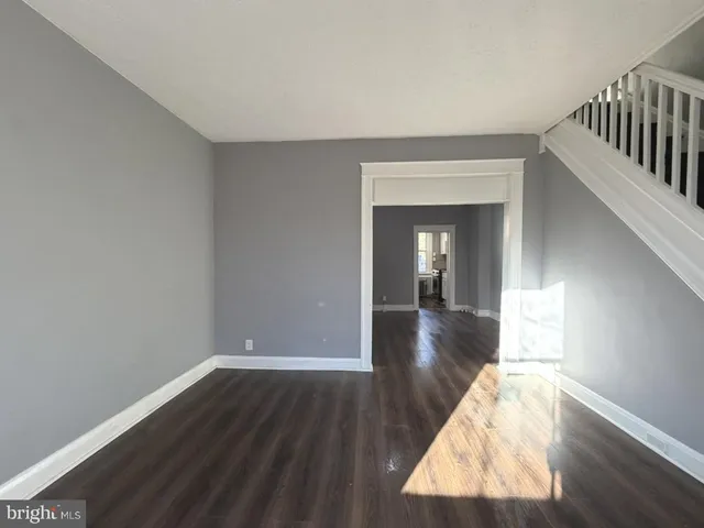 a view of hallway with wooden floor and stairs