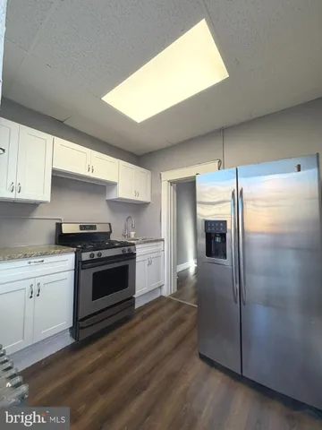 a kitchen with granite countertop a refrigerator and a stove