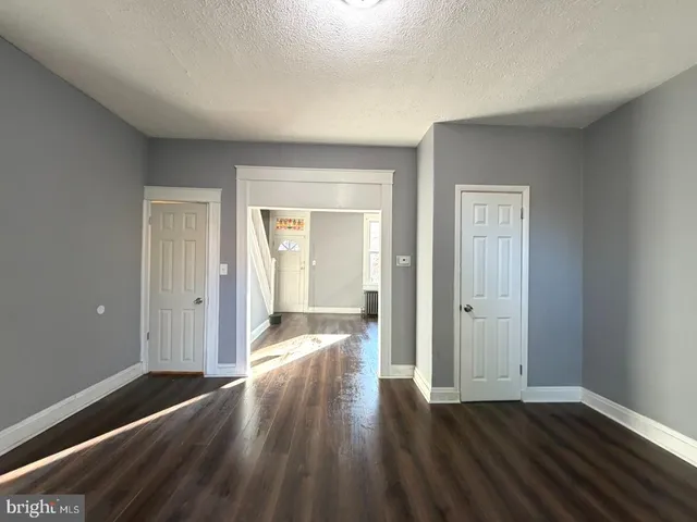 a view of a hallway with wooden floor and closet