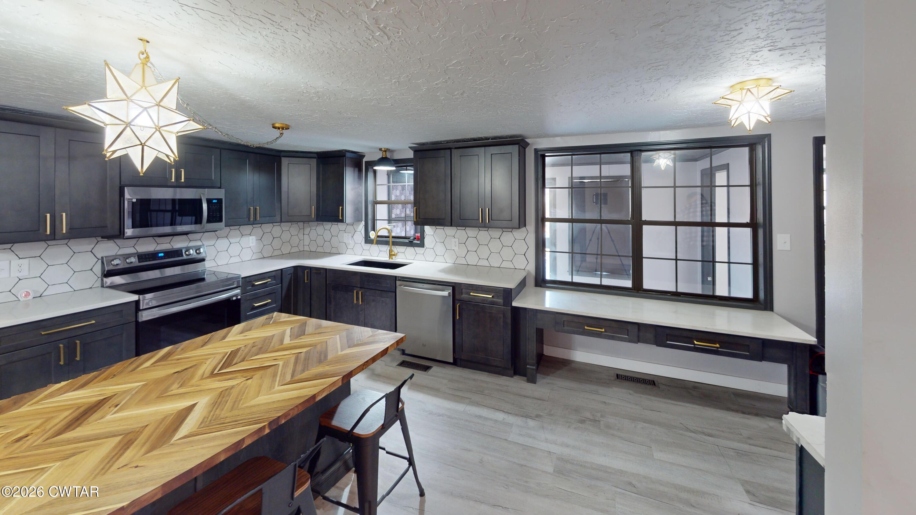 48 Miston Tank Road Ridgely, TN 38080 - Photo 12 of 18 a kitchen with stainless steel appliances kitchen island granite countertop a stove a sink and a microwave