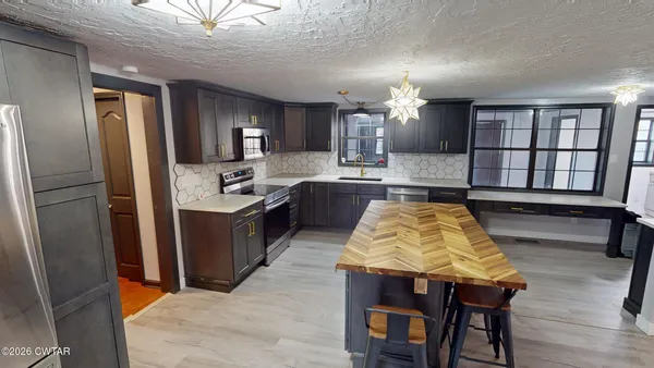 a large kitchen with kitchen island a large counter space and stainless steel appliances