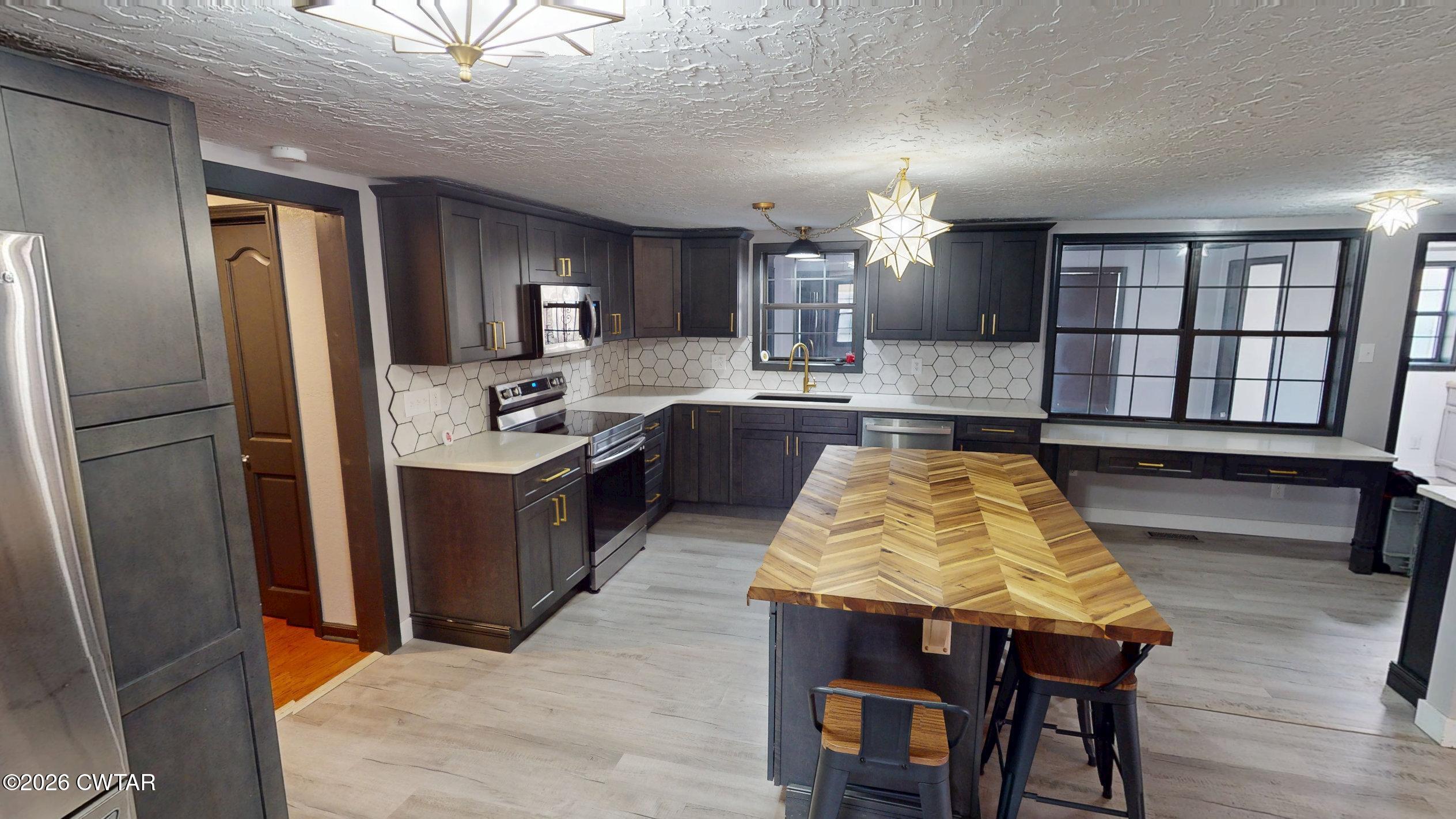 48 Miston Tank Road Ridgely, TN 38080 - Photo 3 of 18 a large kitchen with kitchen island a large counter space and stainless steel appliances