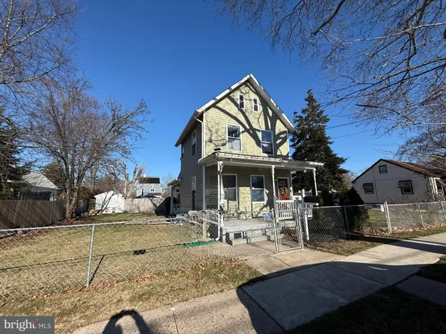 a view of a backyard with a wooden fence and a bench