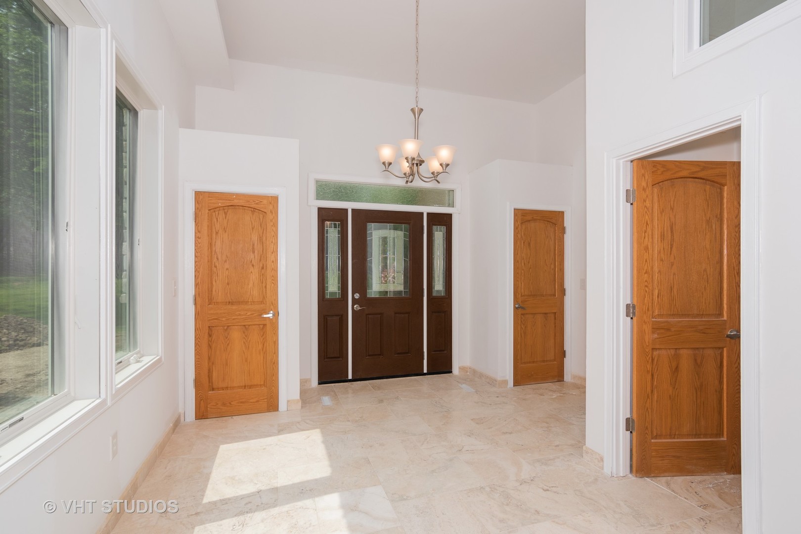 34W101 Army Trail Road Wayne, IL 60184 - Photo 3 of 20 an empty room that has a chandelier fan and kitchen view