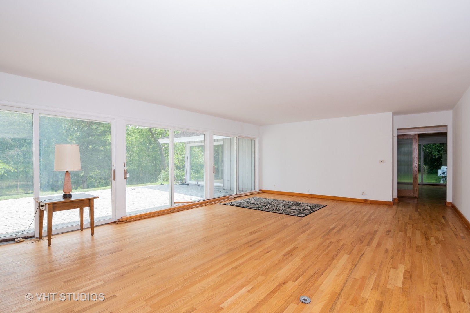 34W101 Army Trail Road Wayne, IL 60184 - Photo 4 of 20 a view of an empty room with wooden floor and a window