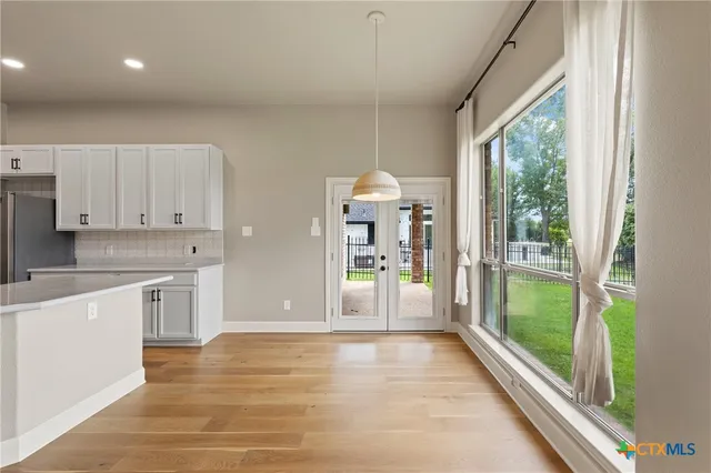 a view of a kitchen with a stove cabinets and a floor to ceiling window
