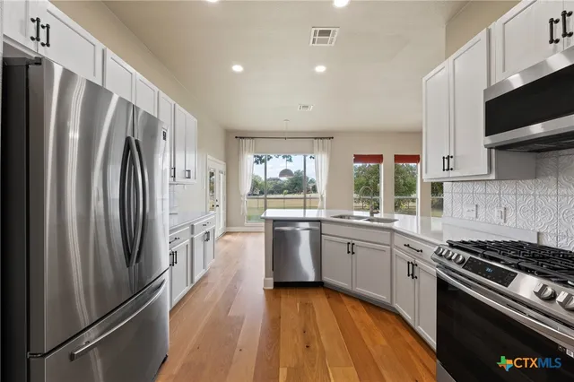 a kitchen with stainless steel appliances a refrigerator sink and stove