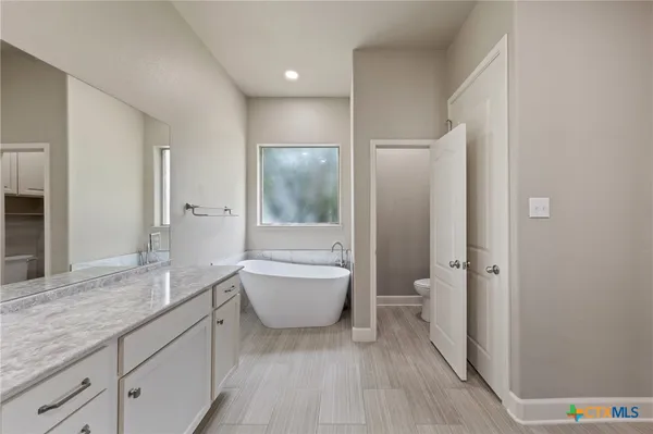 a spacious bathroom with a granite countertop sink toilet and shower