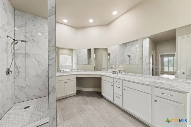 a spacious bathroom with a granite countertop sink mirror and shower