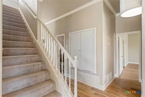 a view of staircase with wooden floor and white walls