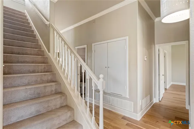 a view of staircase with wooden floor and white walls