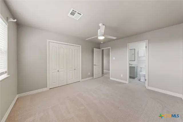 a view of an empty room with window and chandelier fan