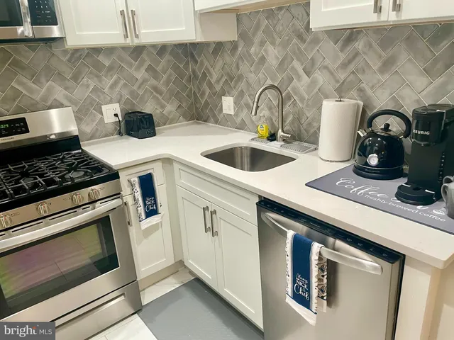 a kitchen with sink a stove and cabinets