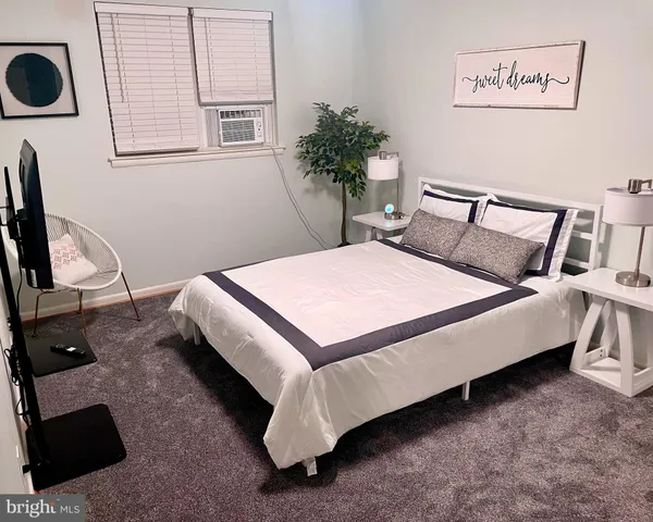 a bed sitting in a bedroom next to a window with wooden floor