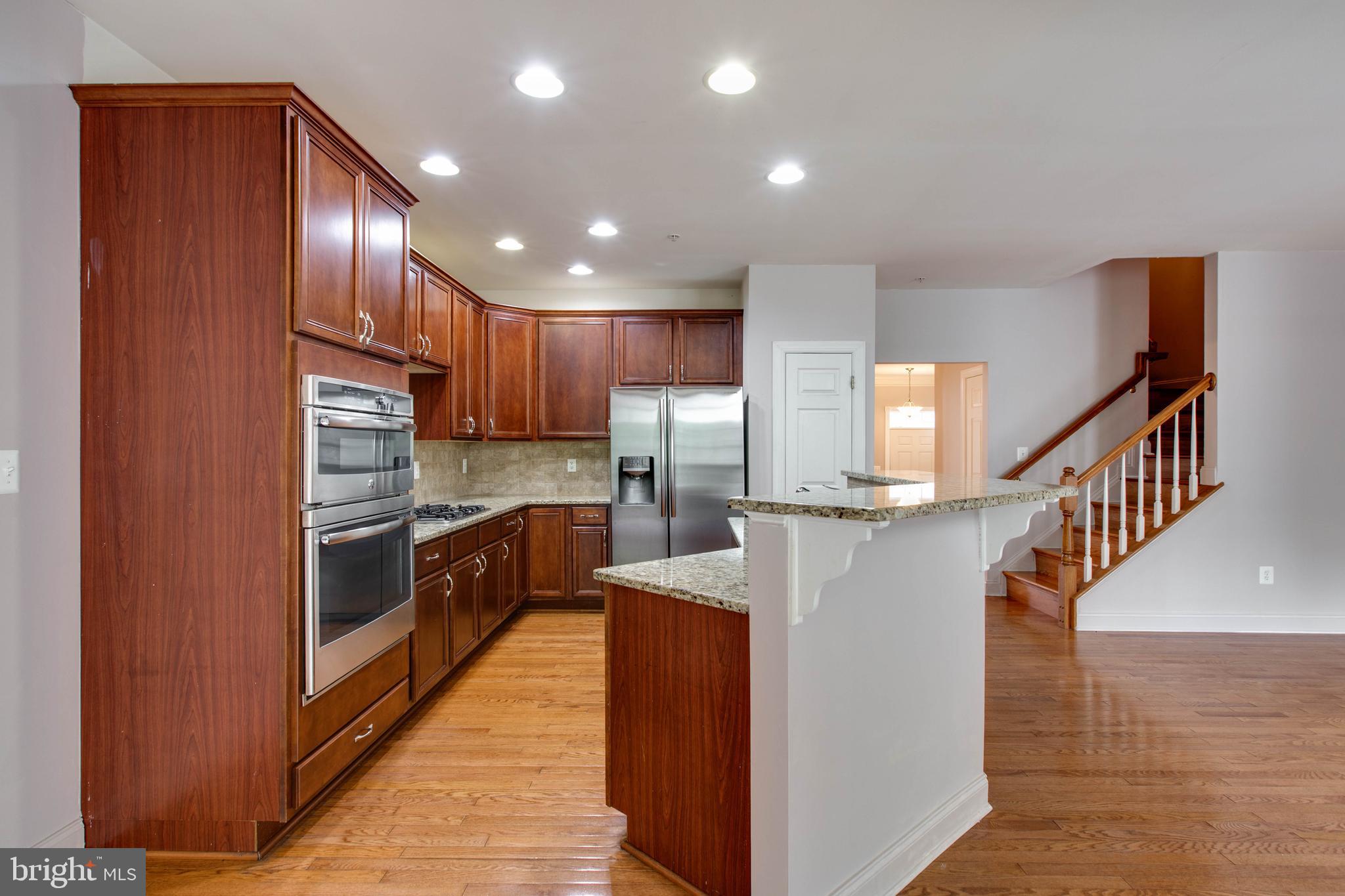 2119 Split Creek Lane Hanover, MD 21076 - Photo 13 of 55 a kitchen with stainless steel appliances granite countertop a refrigerator a stove and a wooden floors