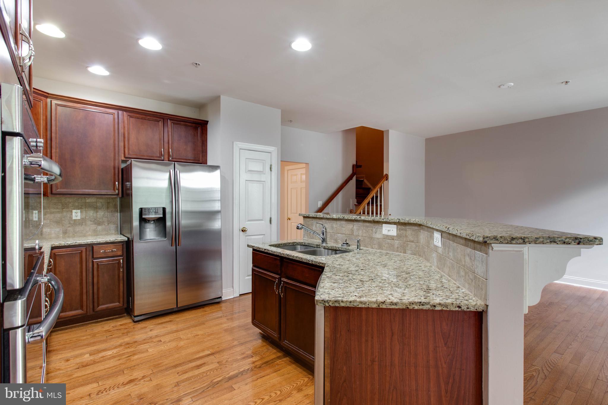 2119 Split Creek Lane Hanover, MD 21076 - Photo 14 of 55 a kitchen with kitchen island granite countertop a sink and refrigerator