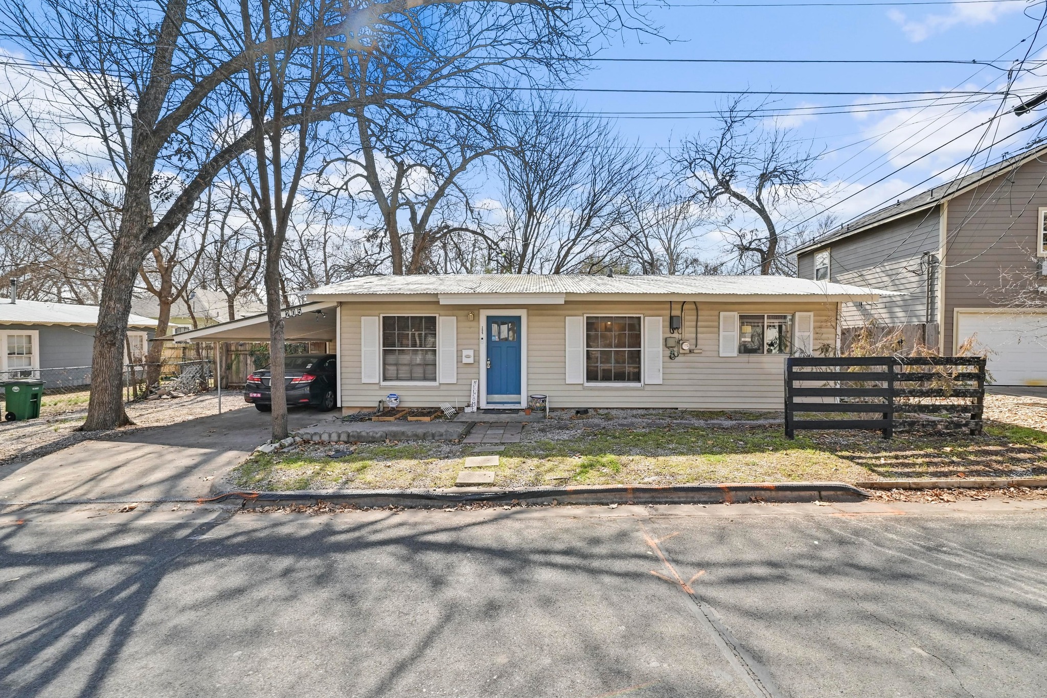 a view of a house with backyard and trees in the background