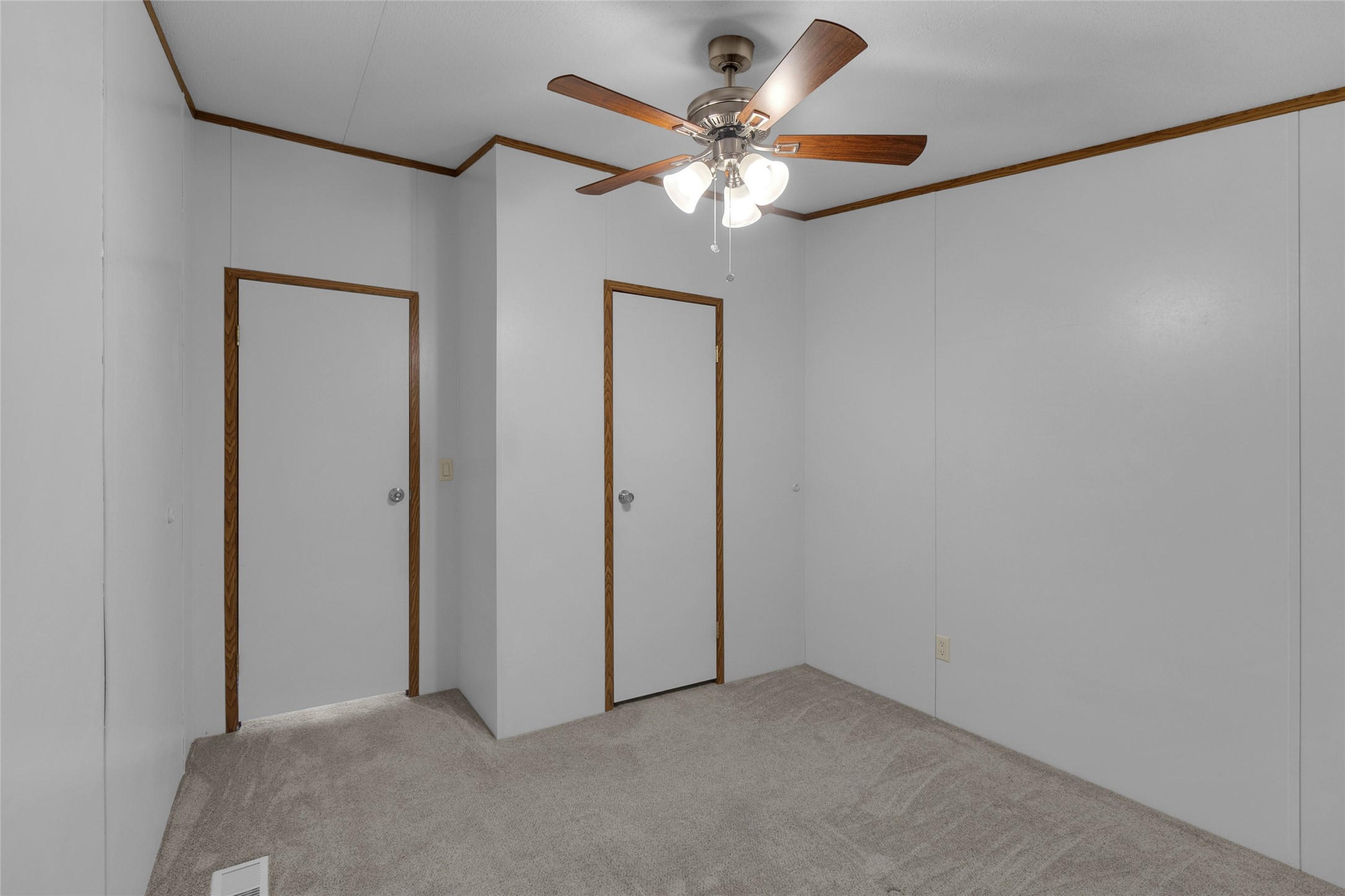 22094 Spear Road Porter, TX 77365 - Photo 30 of 45 The third bedroom showcases neutral colored walls complemented by wood trim and carpeted flooring. It features a ceiling fan with lighting and two doors, one providing access to the room and the other leading to a conveniently sized, functional closet.
