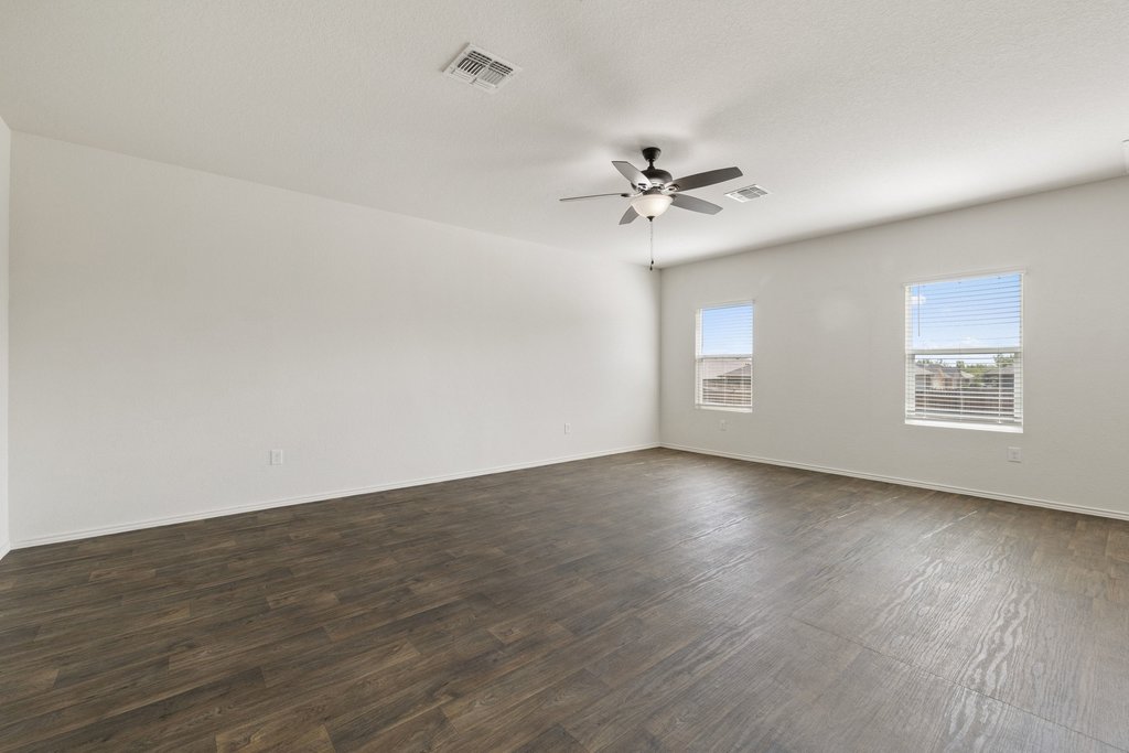 15011 Tuff Rd Manor Manor, TX 78653 - Photo 14 of 37 Spacious second living area or game room with a ceiling fan, wood-look flooring, and bright natural light from two windows.
