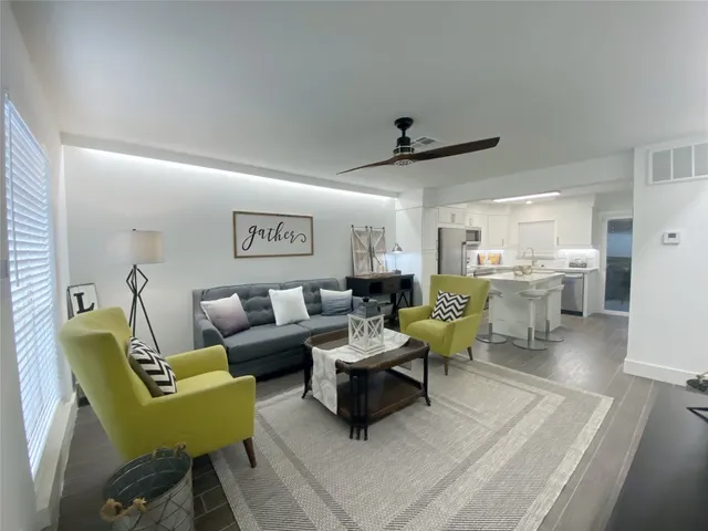 a living room with furniture and a wooden floor