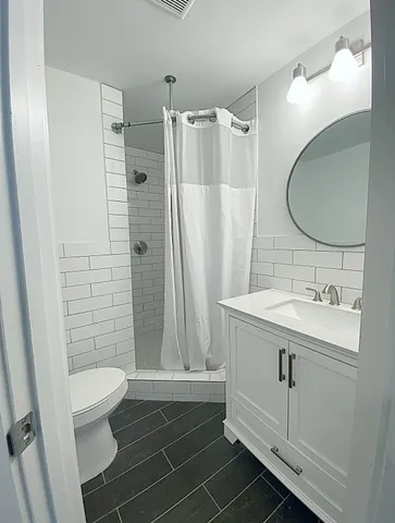 a bathroom with a sink a toilet and shower
