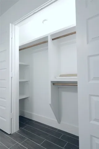 a view of walk in closet with empty racks