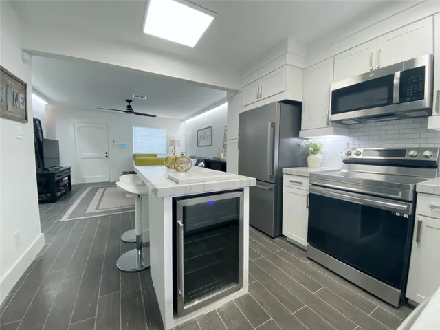 a kitchen with stainless steel appliances a stove a microwave and a refrigerator