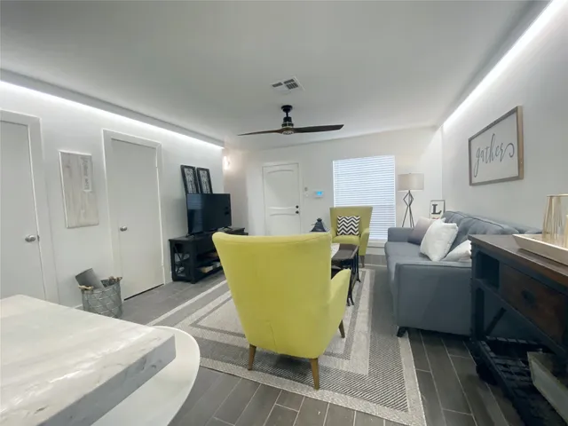 a living room with furniture and a chandelier