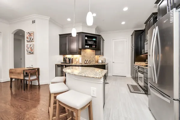 a kitchen with stainless steel appliances kitchen island granite countertop a refrigerator and a stove top oven