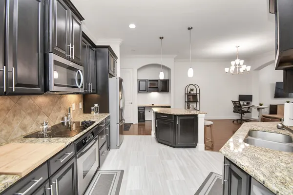 a kitchen with stainless steel appliances granite countertop a sink stove and refrigerator
