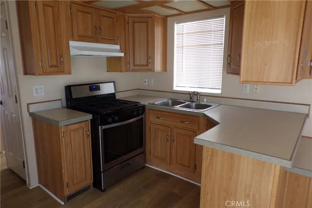 a kitchen with stainless steel appliances a sink stove and cabinets