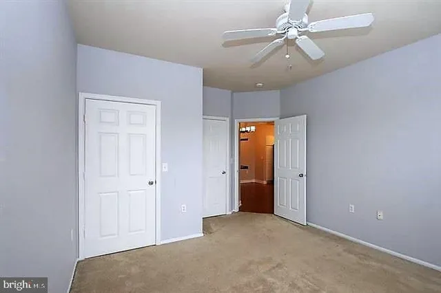 a view of a big room with closet and a chandelier fan