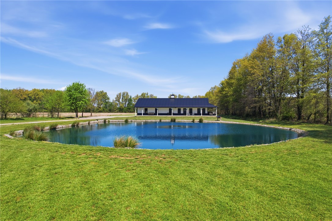1602 Westboro Road Blanchester, OH 45107 - Photo 14 of 81 This tranquil property features a serene pond, lush green surroundings, and a charming residence.