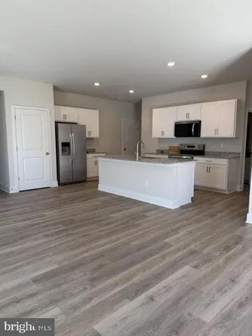 a view of kitchen with refrigerator stove microwave and cabinets
