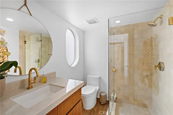 a bedroom with a bed and a large mirror on the dresser