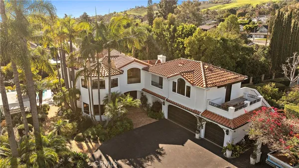a view of a swimming pool with lawn chairs under an umbrella