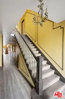 a view of a hallway with wooden floor and staircase