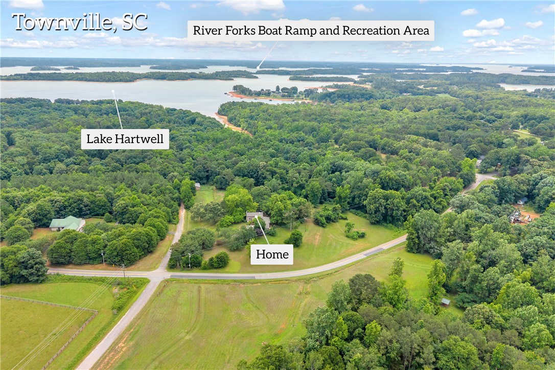 200 Chenault Road Townville, SC 29689 - Photo 36 of 47 An aerial perspective reveals the property's serene lake and lush, tree-filled landscape.