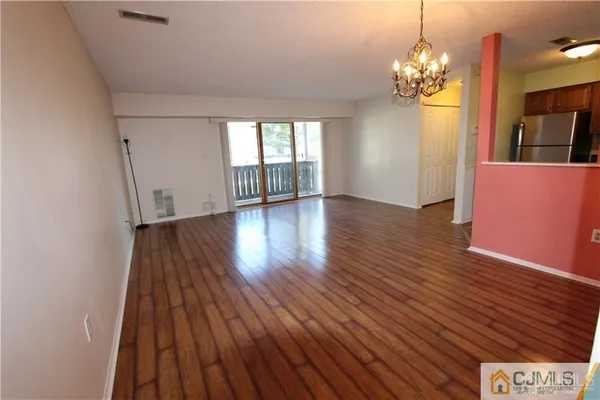 a view of a room with wooden floor and chandelier