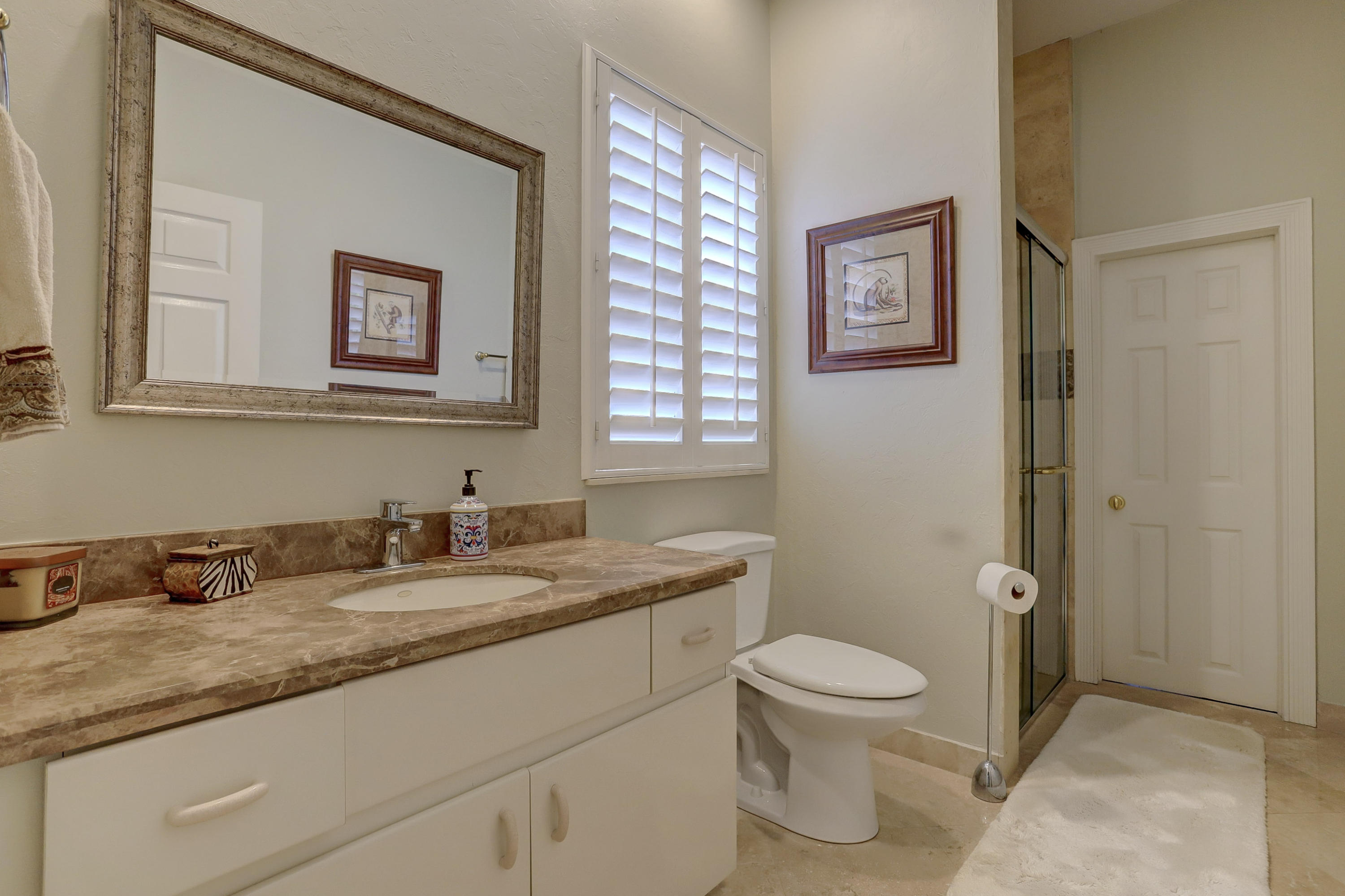1605 Southwest 20th Avenue Boca Raton, FL 33486 - Photo 47 of 70 a bathroom with a granite countertop toilet a sink and a mirror