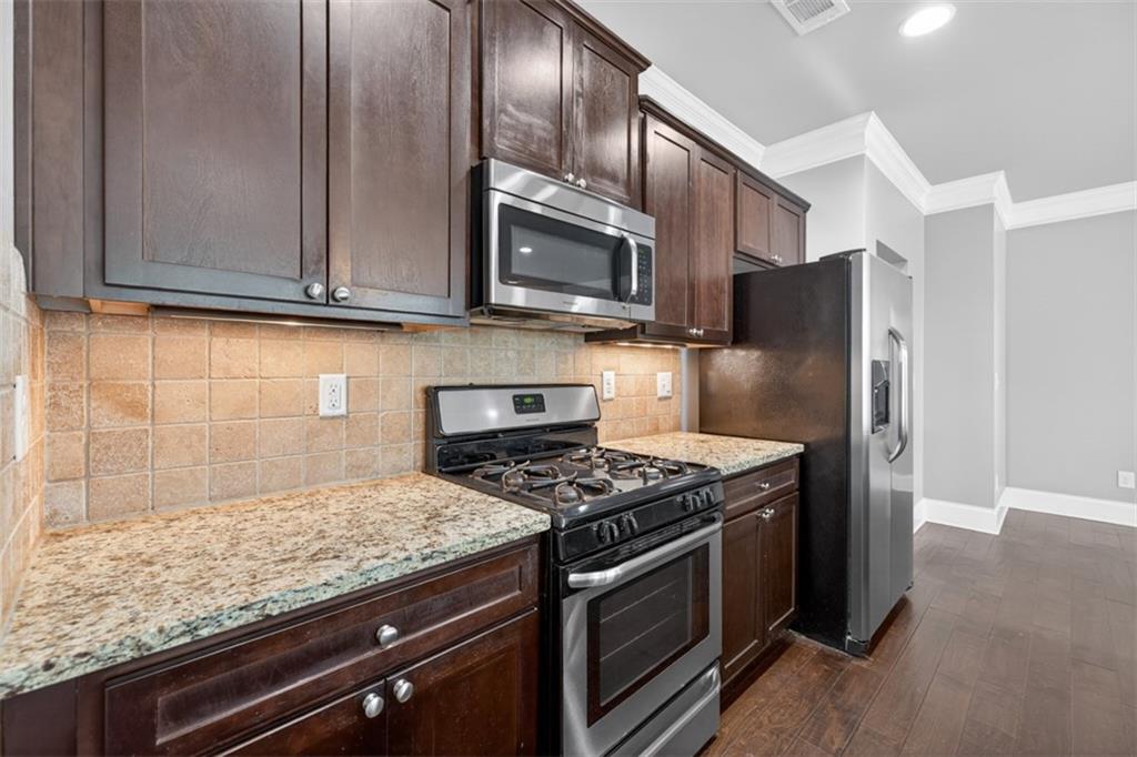 2854 Jordan Oaks Lane, Unit 8 Decatur, GA 30033 - Photo 12 of 41 a kitchen with granite countertop wooden cabinets and stainless steel appliances