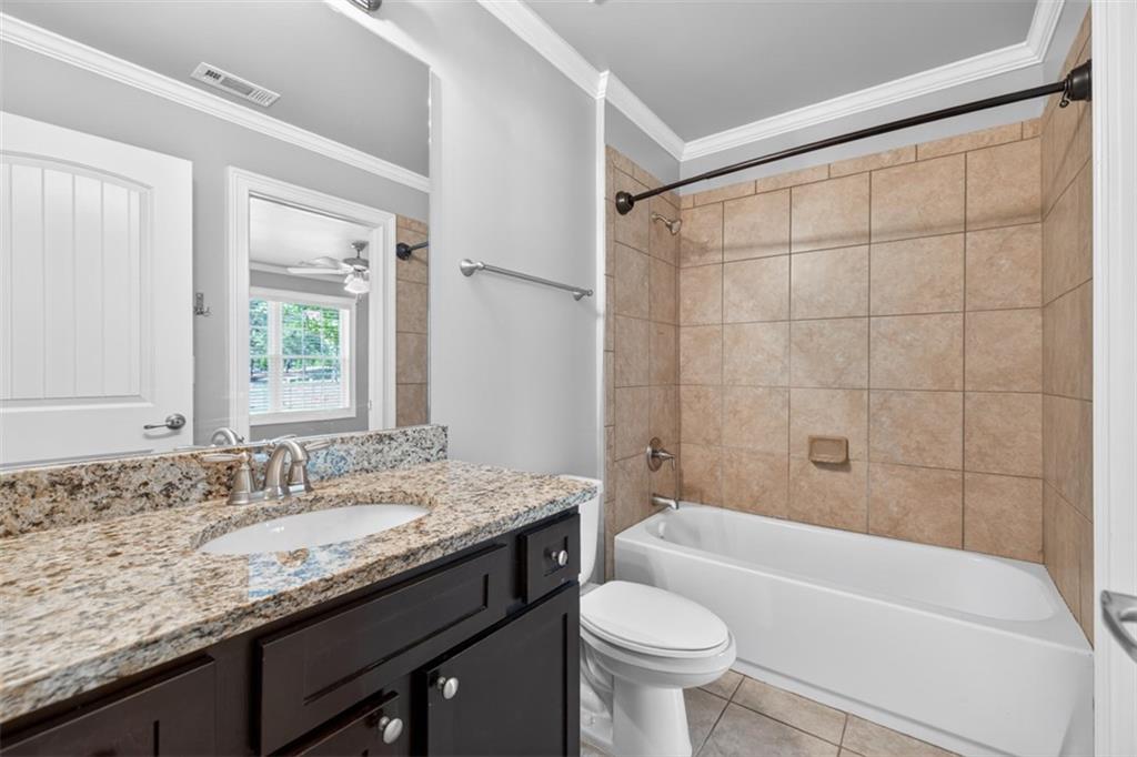 2854 Jordan Oaks Lane, Unit 8 Decatur, GA 30033 - Photo 28 of 41 a bathroom with a granite countertop sink a toilet a mirror a bathtub and shower