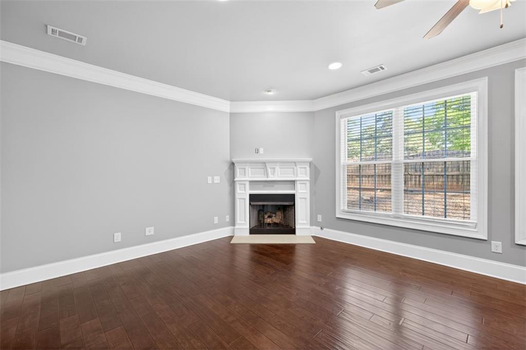 2854 Jordan Oaks Lane, Unit 8 Decatur, GA 30033 - Photo 6 of 41 an empty room with wooden floor fireplace and windows